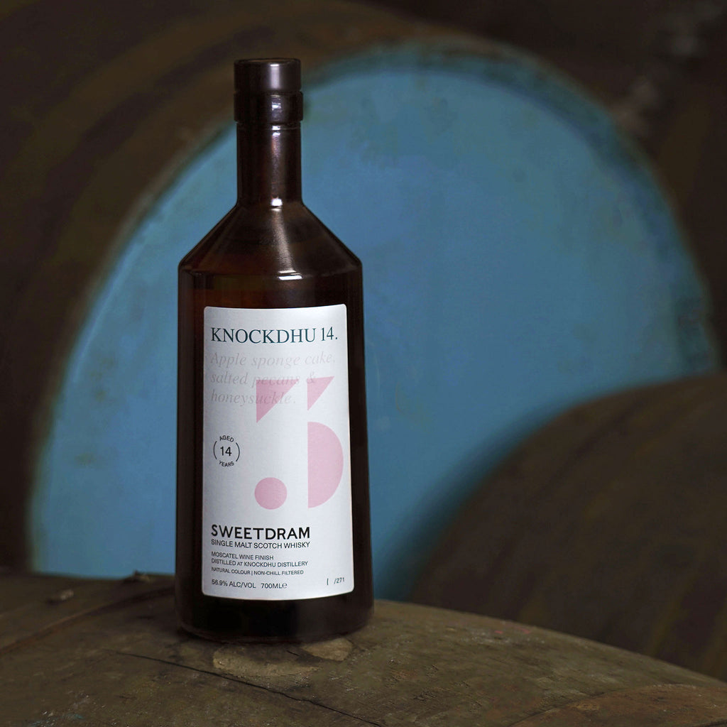 750ml bottle of Knockdhu 14-year-old single-cask Whisky sitting on a cask.